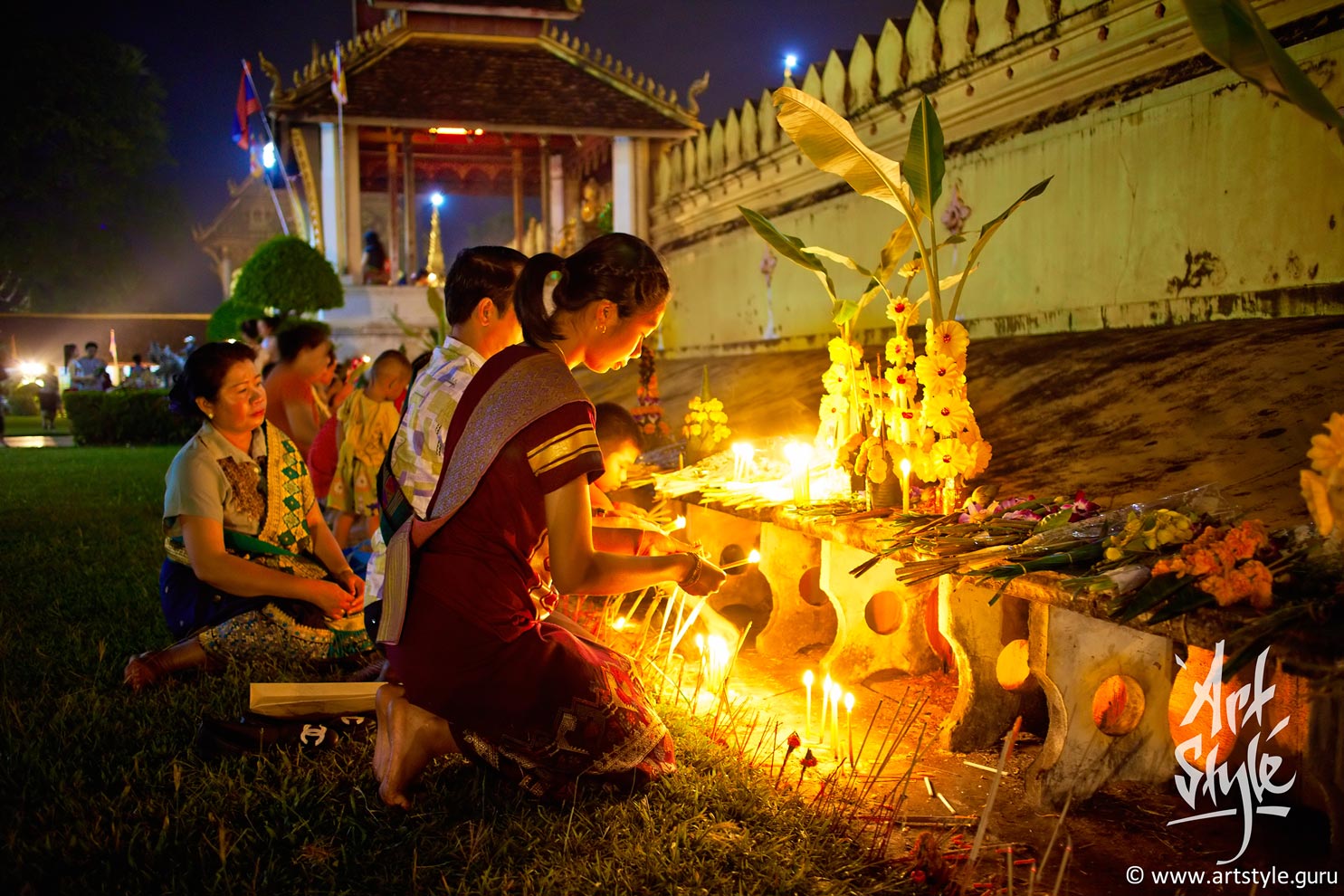Laotian family in national costumes prays at Pha That Luang festival, Vientiane, Laos.