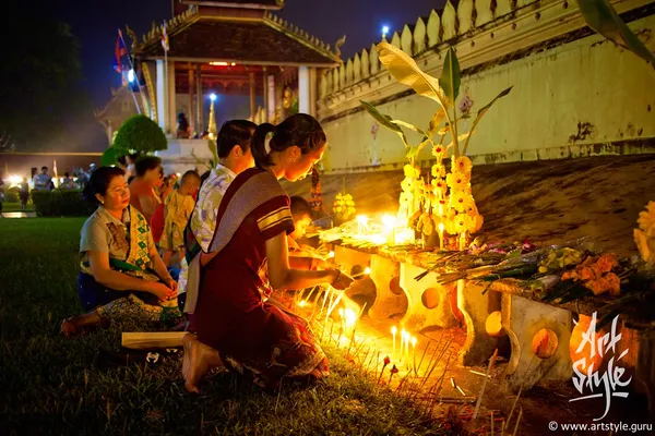 Laotian family in national costumes prays at Pha That Luang festival, Vientiane, Laos.